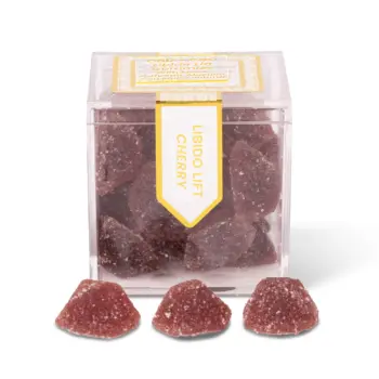 TribeTokes CBD Libido Lift Cherry Gummies in a clear cube box with three sugar-coated gummies in front on a white background