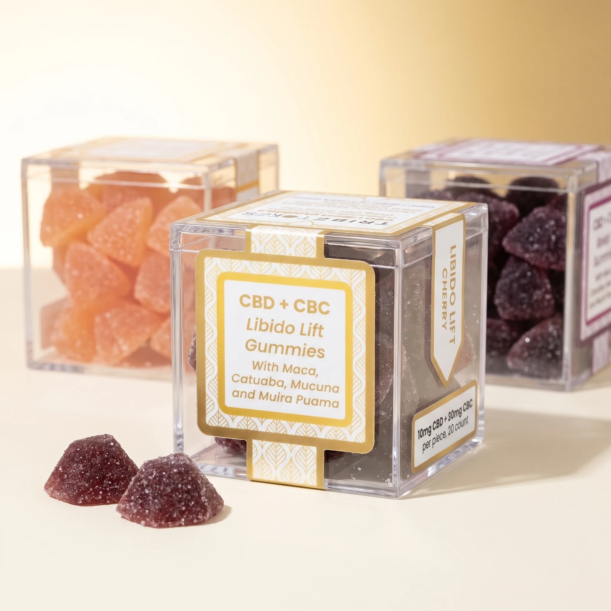 Three flavors of TribeTokes CBD Libido Lift gummies lined up, with the Cherry box in front showing 10mg CBD and 20mg CBC per piece, and two other varieties behind
