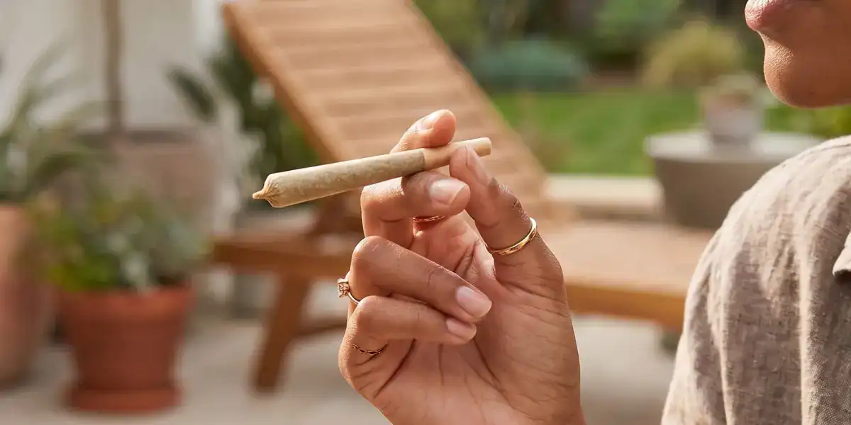 Person holding a TribeTokes THCa pre-roll in a relaxed outdoor setting, illustrating how THCa products are consumed