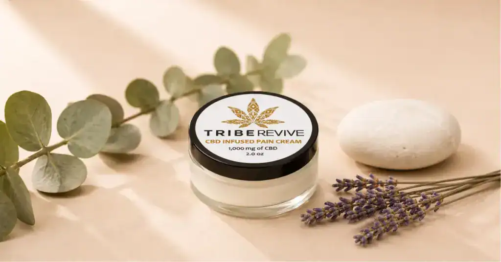 TribeRevive CBD pain cream jar with eucalyptus and lavender botanicals on a cream background representing cannabis topical absorption and localized effects
