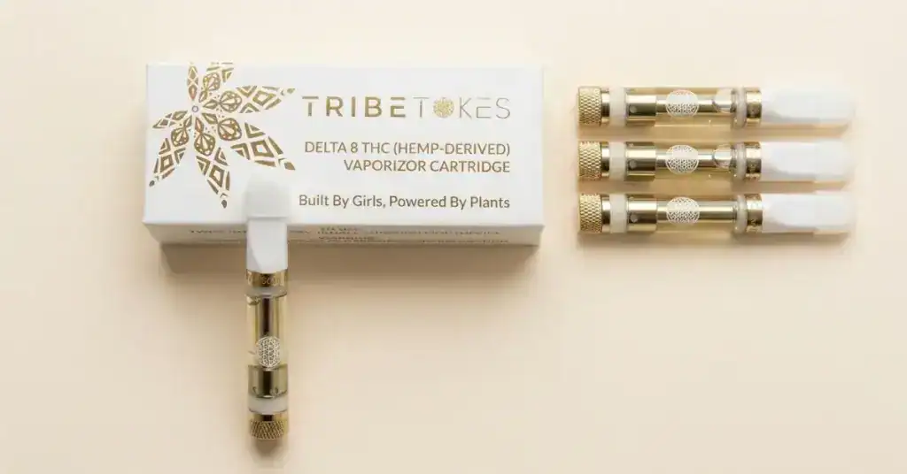 TribeTokes Delta 8 THC vape cartridges in multiple strain options arranged on cream background, representing the complete Delta 8 carts lineup
