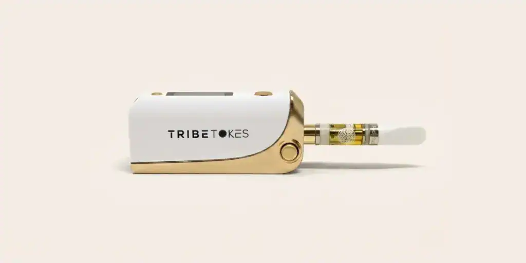 Close-up of a TribeTokes Delta 8 THC vape cartridge attached to a 510-thread battery on cream background