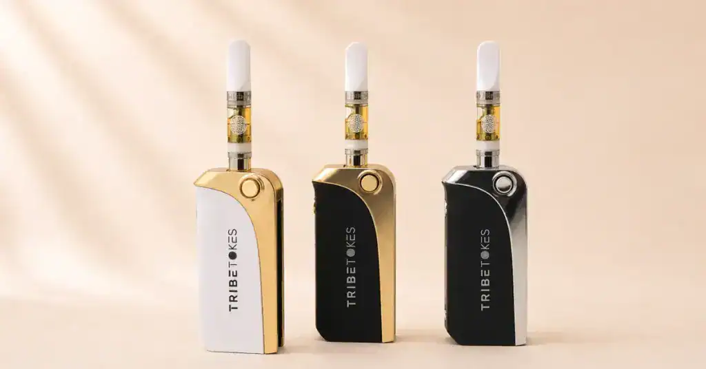 Three TribeTokes Saber vape batteries in different colorways with cartridges attached on a cream background representing the complete 510 thread vape battery guide for voltage and compatibility