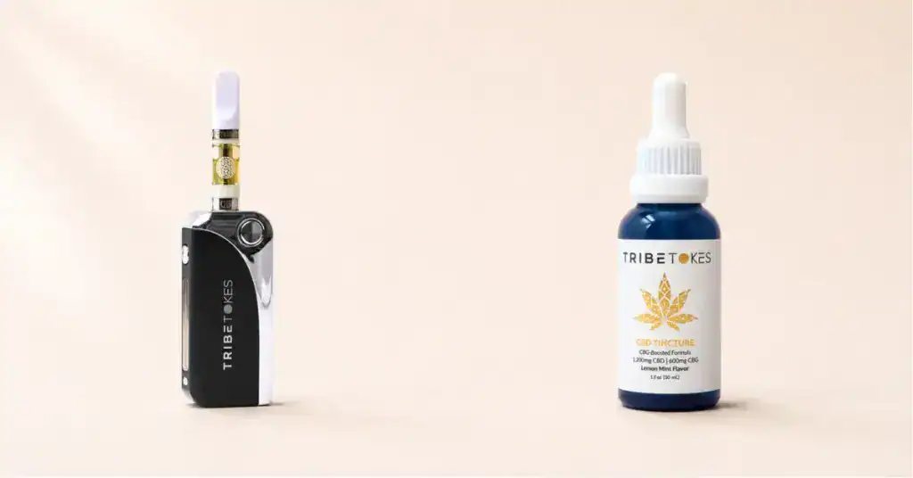 TribeTokes vape cartridge and CBD tincture bottle side by side on a cream background representing the comparison between vaping and tinctures for onset duration and delivery method