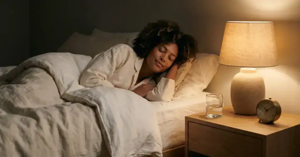 Woman resting peacefully in bed at night — illustrating optimal cannabis timing for sleep
