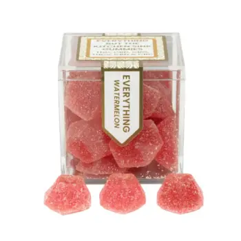 TribeTokes Everything But The Kitchen Sink Watermelon gummies in a clear cube box with three sugar-coated red gummies in front on a white background