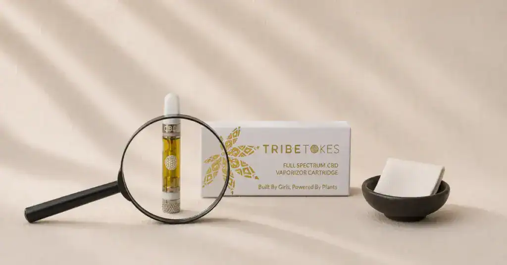 TribeTokes cannabis product with magnifying glass on cream linen — editorial flatlay representing consumer scrutiny of cannabis COA lab reports and how to spot fake or incomplete certificates of analysis