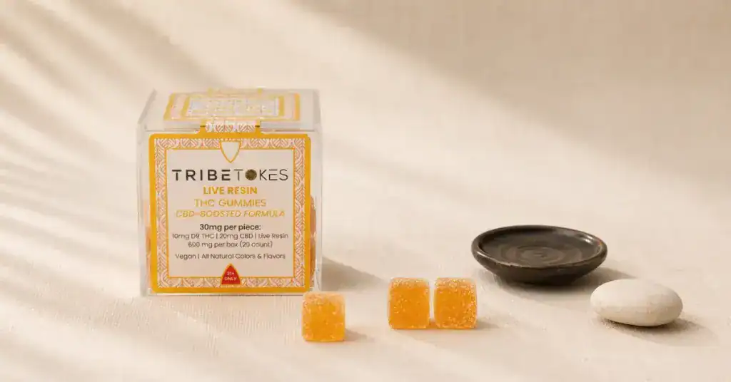 TribeTokes THC gummies box with individual gummy pieces arranged on cream linen — editorial flatlay representing THC gummy dosage chart, milligram guide and how much to take for beginners and experienced users