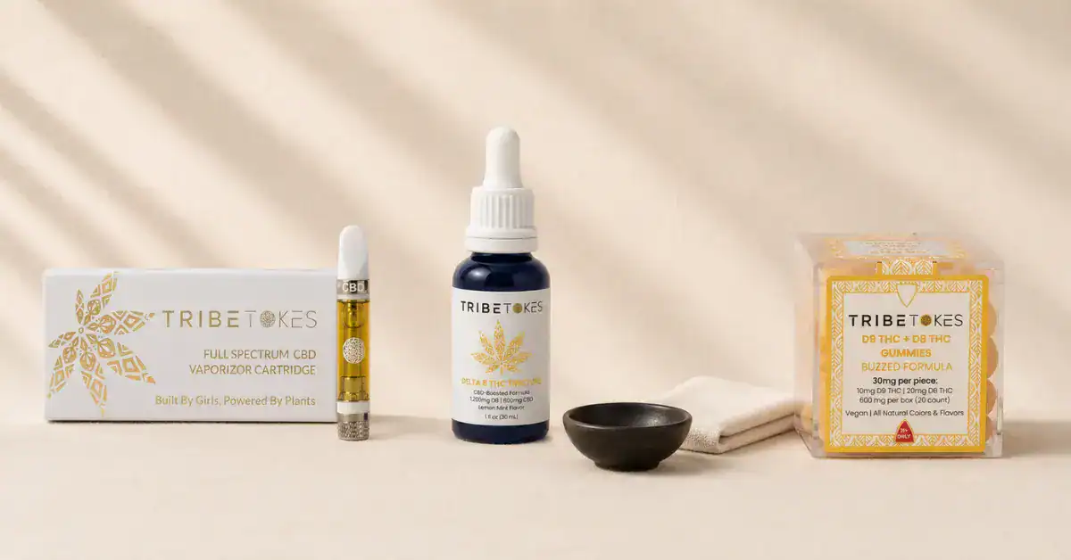 TribeTokes cannabis products flatlay on cream linen — cart, tincture, and gummies representing every-batch third-party lab testing process and COA transparency for hemp vape and edible products