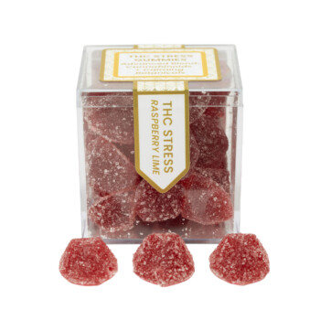TribeTokes THC Stress Raspberry Lime gummies in a clear cube box with three sugar-coated red gummies in front on a white background