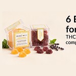 Stress relief gummies scattered beside a small jar and dried botanicals