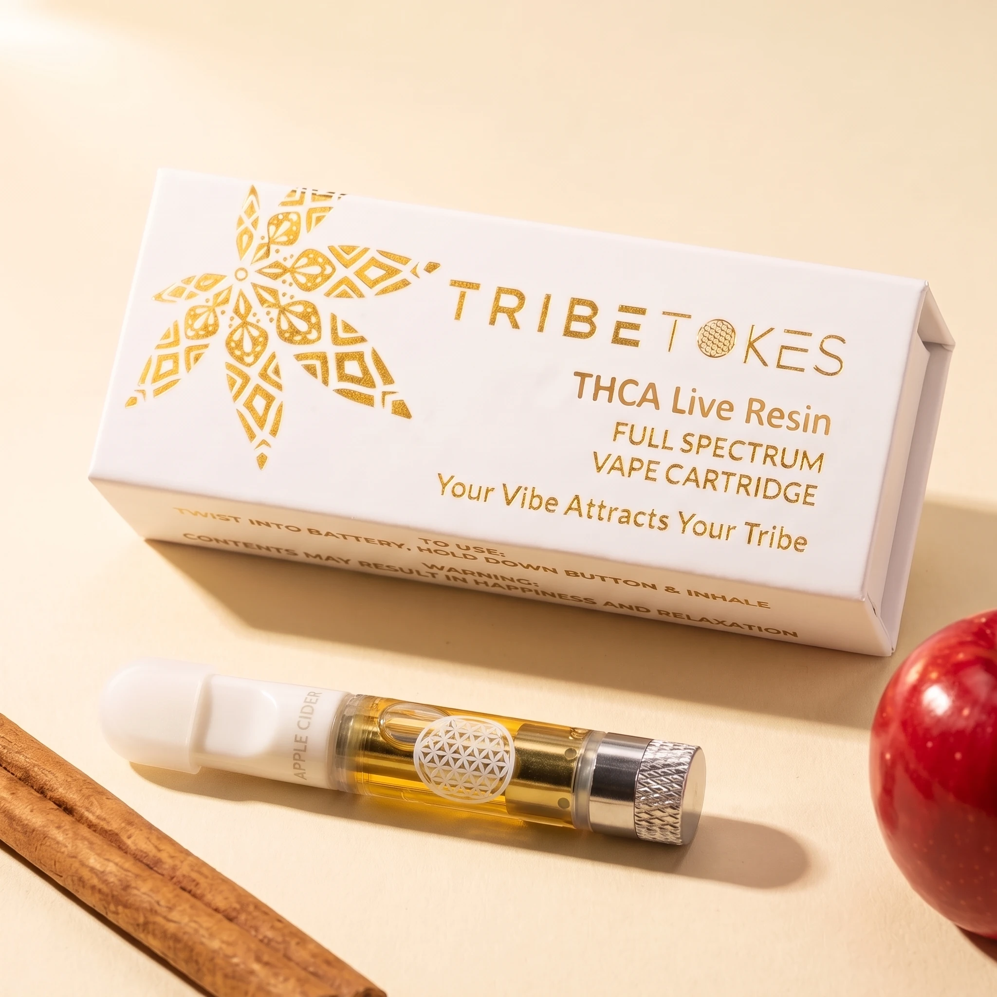 Spiced Apple Cider THCa live resin vape cart beside its TribeTokes box with a cinnamon stick and a red apple