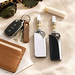 Saber Key Fob and TribeMINI discreet cart batteries resting among car keys, sunglasses and lip balm on a cream linen surface